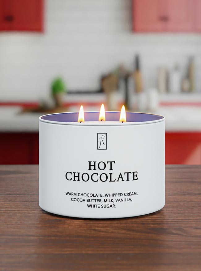 Candle labeled 'Hot Chocolate' on a wooden surface with a blurred kitchen background