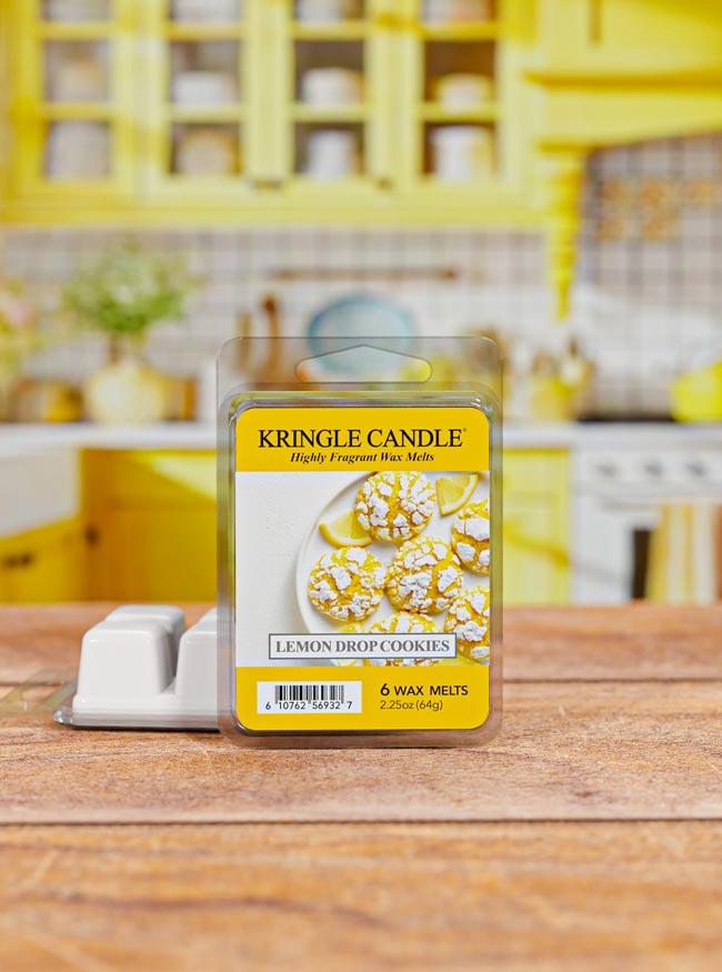 Kringle Candle Lemon Drop Cookies wax melts packaging on a wooden surface with a blurred kitchen background.