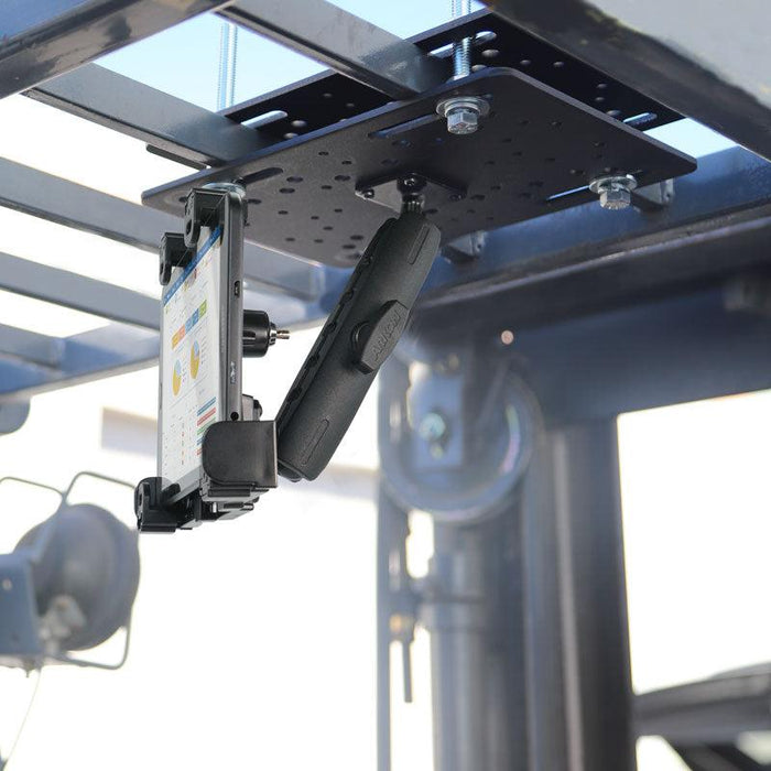 The LockVise™ Locking Forklift Overhead Guard Tablet Mount with 6 Metal Shaft is securely bolted under a metal frame, holding a tablet that displays charts and data, with industrial equipment visible in the warehouse background.
