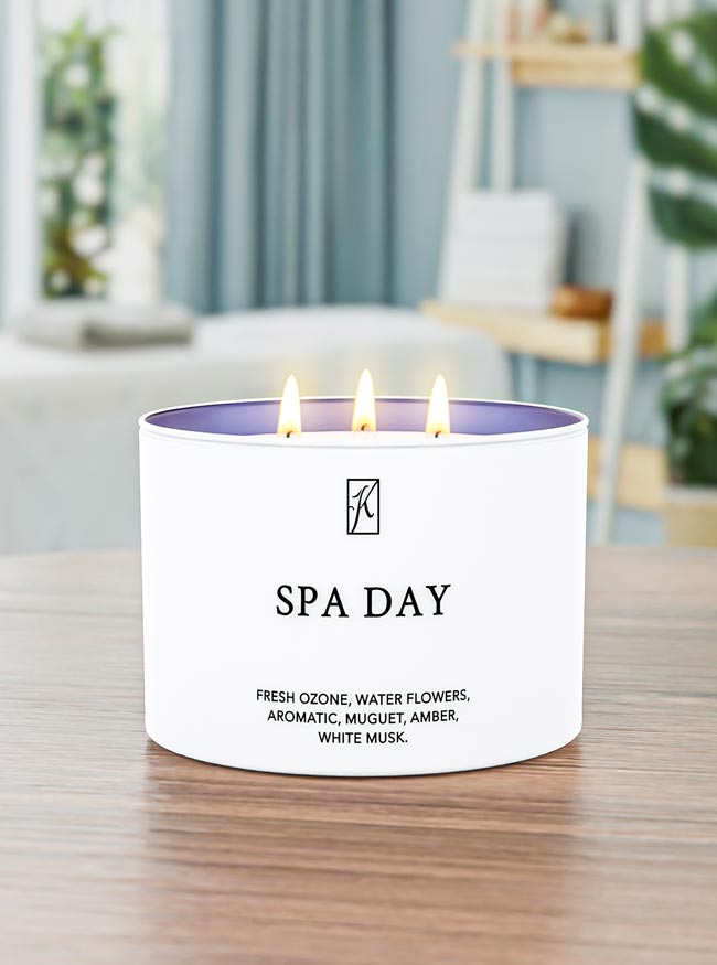 Candle with 'SPA DAY' text on a table in a blurred indoor setting