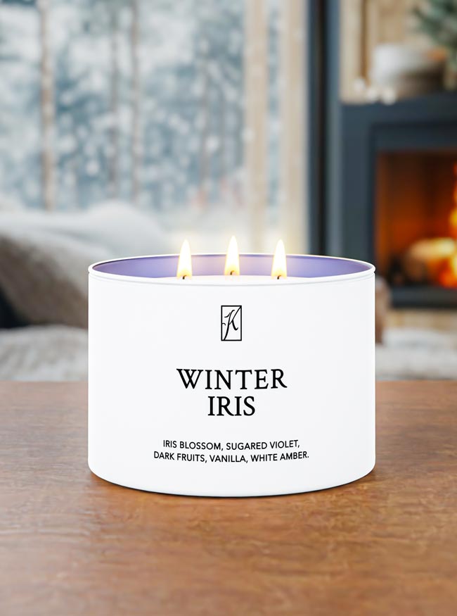 Candle labeled 'Winter Iris' on a table with a blurred background