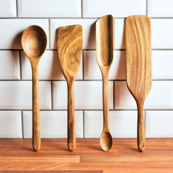 The Acacia Wood Tool Sets, featuring four elegantly designed kitchen tools safe for use with nonstick cookware, rest beautifully against a white tile backsplash.