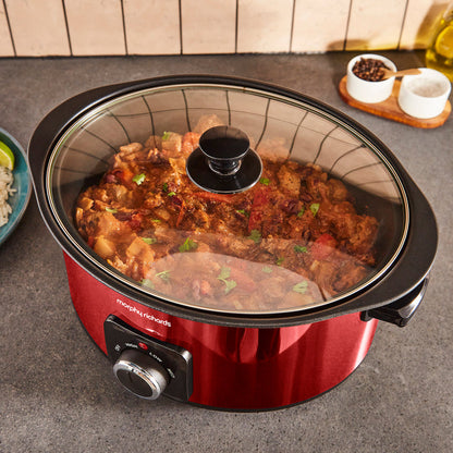 Red Morphy Richards slow cooker with food inside on a kitchen counter