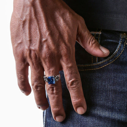 A man wearing the large blue stone biker ring, with hand resting on jeans.