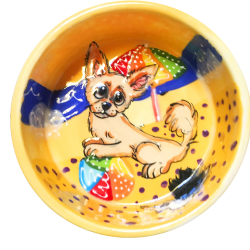 image of chihuahua playing with beach ball on ceramic yellow bowl with beach background hand painted by faux paw artist Debby Carman