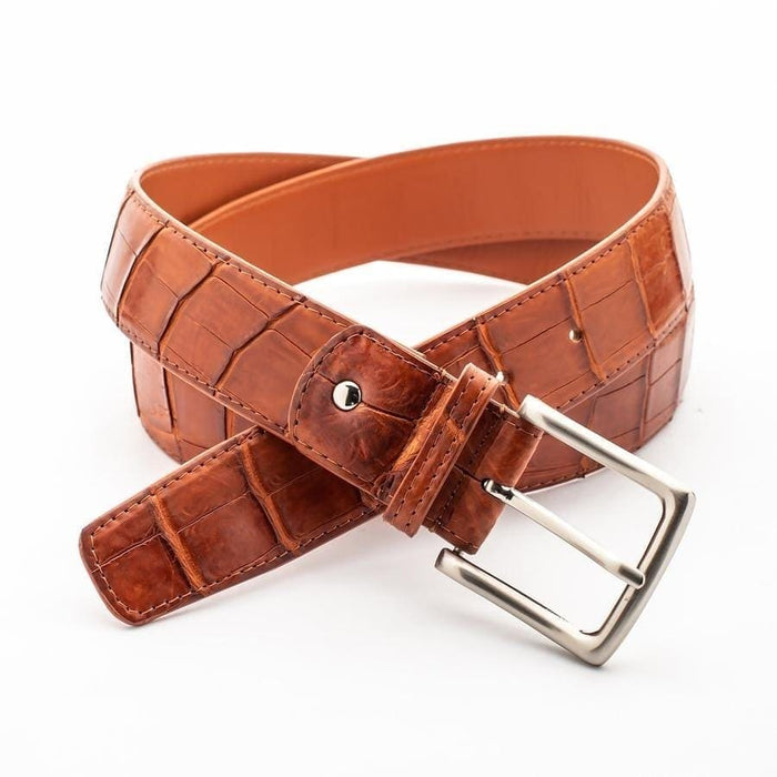 Handcrafted cognac crocodile belt displaying natural scale pattern with brushed silver buckle