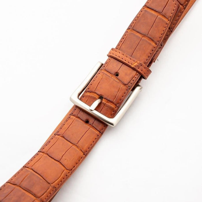 Crocodile leather dress belt buckle closeup showing brushed silver hardware and belt holes