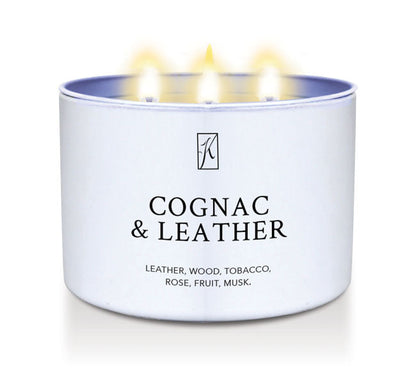 Candle in a white tin container labeled 'Cognac & Leather' with flames on a white background