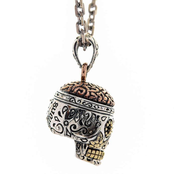 A premium, handcrafted sugar skull pendant, artfully combining sterling silver, brass, and copper.