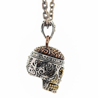A premium, handcrafted sugar skull pendant, artfully combining sterling silver, brass, and copper.