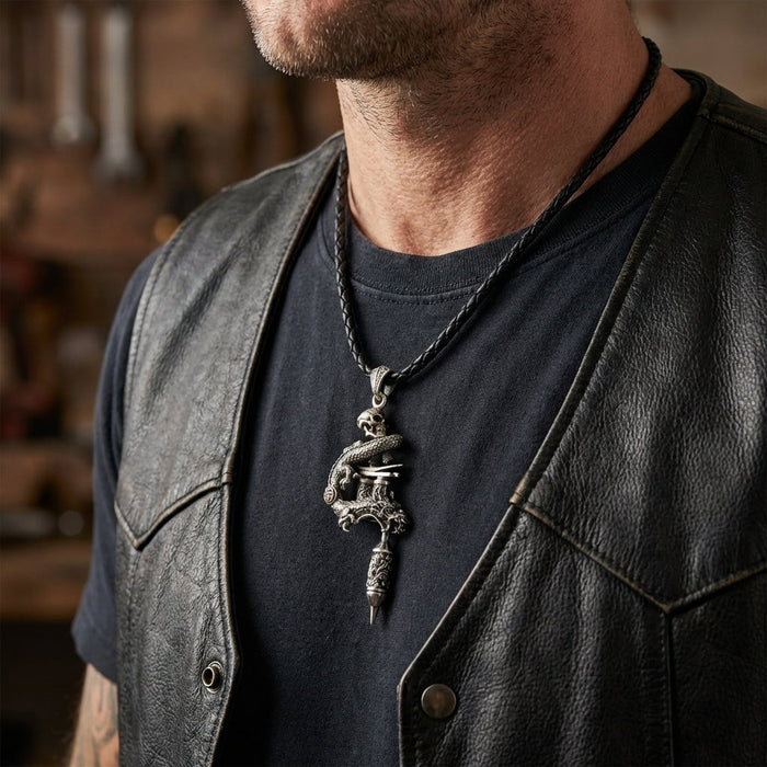 Male tattoo artist wearing dragon skull tattoo machine pendant with leather vest