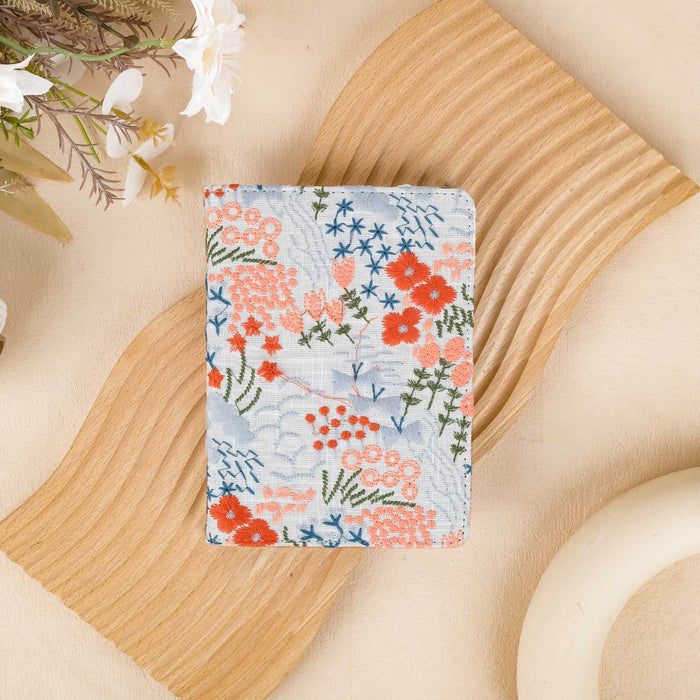 Floral patterned notebook on a wooden surface with flowers in the background