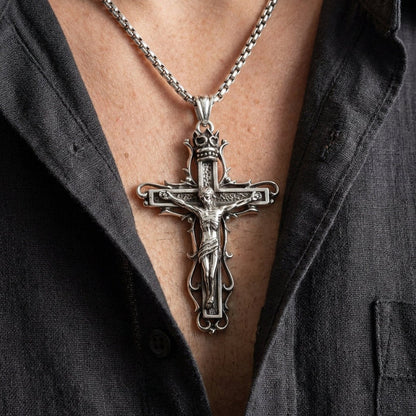 Man wearing gothic sterling silver crucifix pendant on box chain necklace with open collar dark shirt