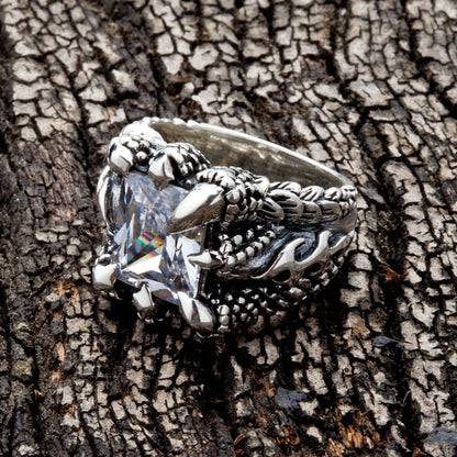 Mens silver ring featuring dragon claws holding a clear topaz stone