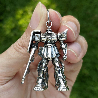 A direct front view of the Zaku II pendant, showing the fine detail of its mono-eye sensor and chest piece.