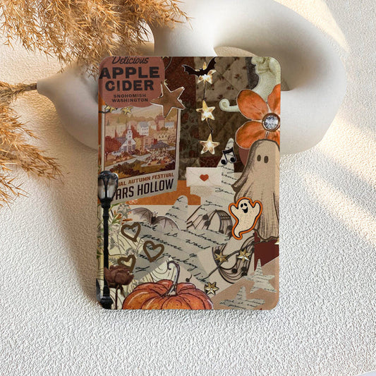 Notebook with Halloween-themed design featuring pumpkins, ghosts, and autumn elements on a textured surface.
