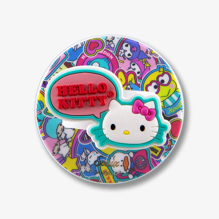 Close-up of magnetic removable phone ring showing red ‘HELLO KITTY’ embossed speech bubble and white Hello Kitty face over colorful character sticker collage on white background