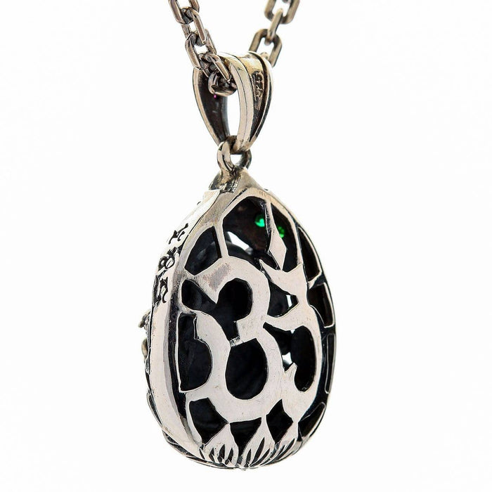 An Om symbol is cut through the back plate, showing the dark stone behind it inside an engraved oval frame.