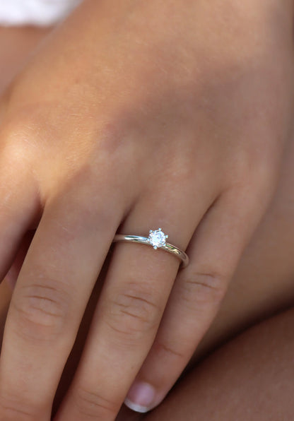 Tjej som bär en diamantring i silver med 0,25 ct rund diamant. Vigsel- eller förlovningsring.