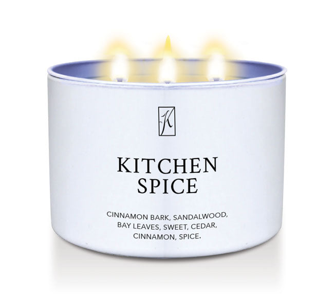 Candle in a white container labeled 'Kitchen Spice' with flames on a white background