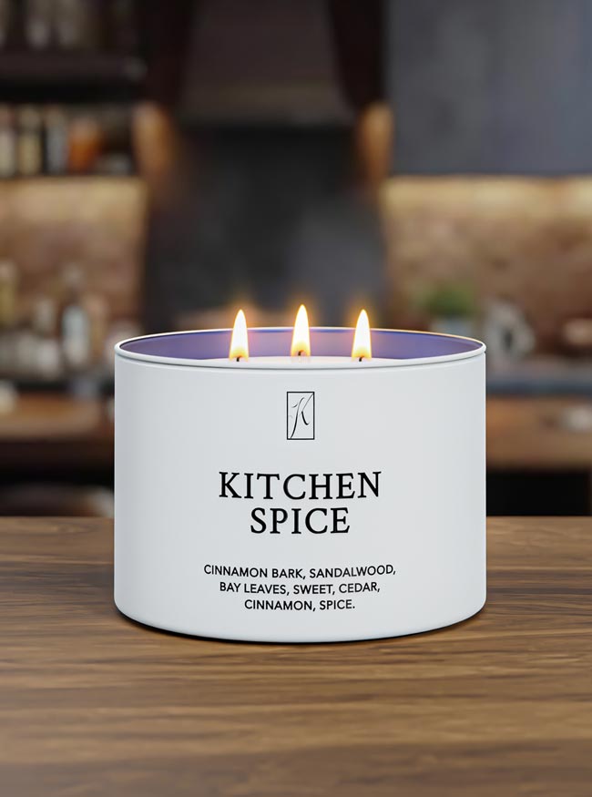 Candle labeled 'Kitchen Spice' with flames on a wooden surface.