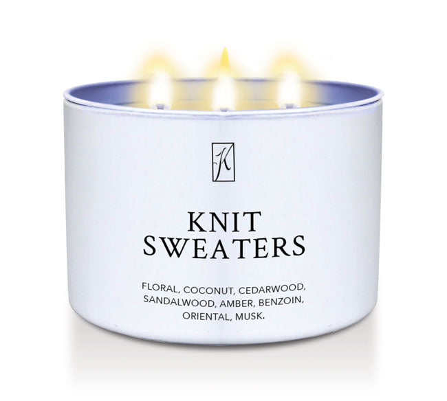 Candle in a white container labeled 'Knit Sweaters' with flames on a white background
