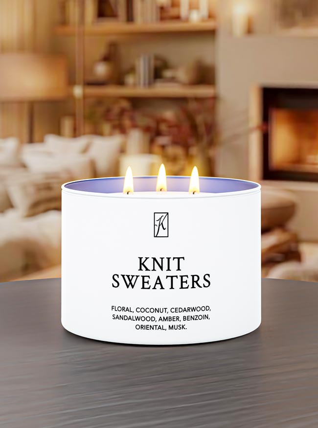 Candle labeled 'Knit Sweaters' with a cozy indoor setting in the background