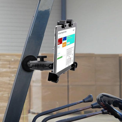 A LockVise™ Locking Magnetic Tablet Mount is attached to a forklift, showing a website with graphs and a calendar. The forklift’s control levers appear in the foreground, while stacked boxes are visible in the background.