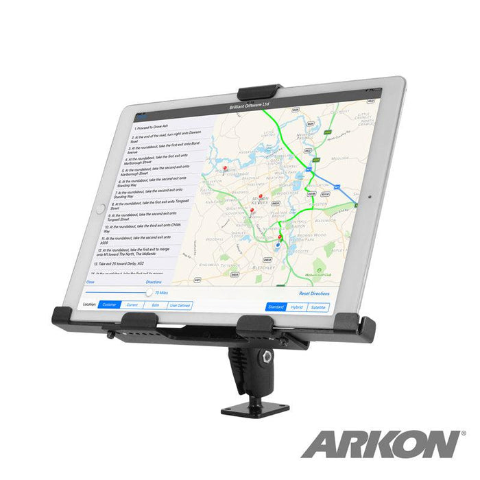 The LockVise™ Metal XL Locking Tablet Holder with Drill Base Mount in sleek black securely holds a tablet displaying map directions. ELD compliant and adjustable, it’s attached to a flat surface with the ARKON logo in the bottom right corner.
