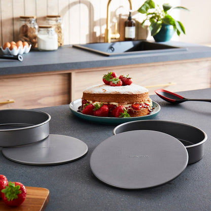 Kitchen counter with cake, pans, and kitchen items