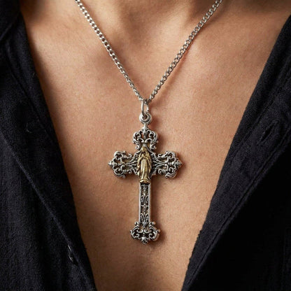 Lifestyle view showing the ornate silver and brass Mary angel cross pendant worn on a chain against a black shirt.