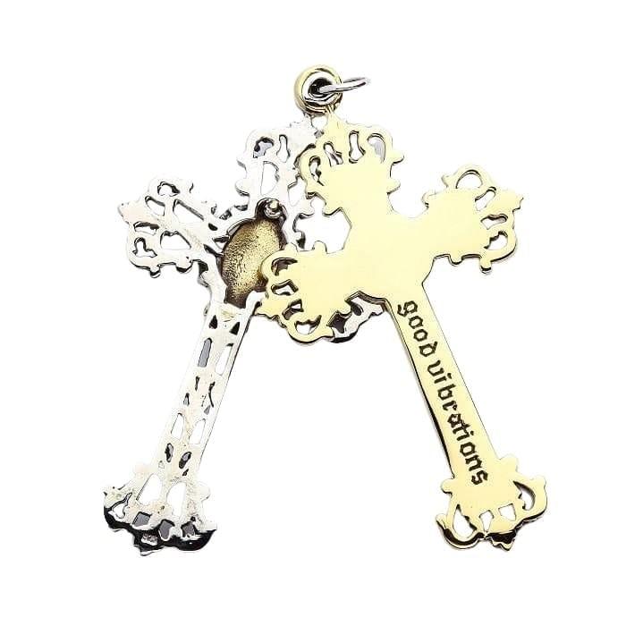 Reverse side of the pendant showing the solid brass cross engraved with 'good vibrations' overlapping the silver frame.