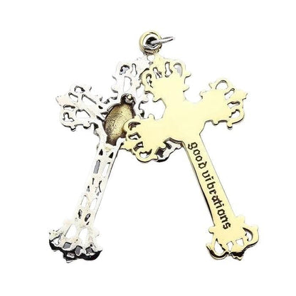 Reverse side of the pendant showing the solid brass cross engraved with 'good vibrations' overlapping the silver frame.
