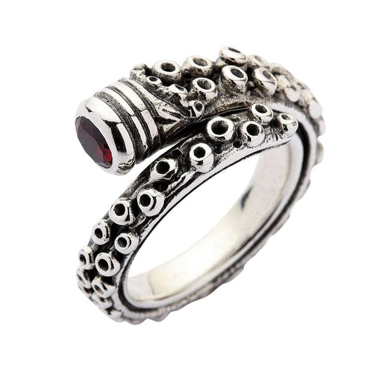 An angled view of the adjustable sterling silver octopus tentacle ring with a red CZ stone.
