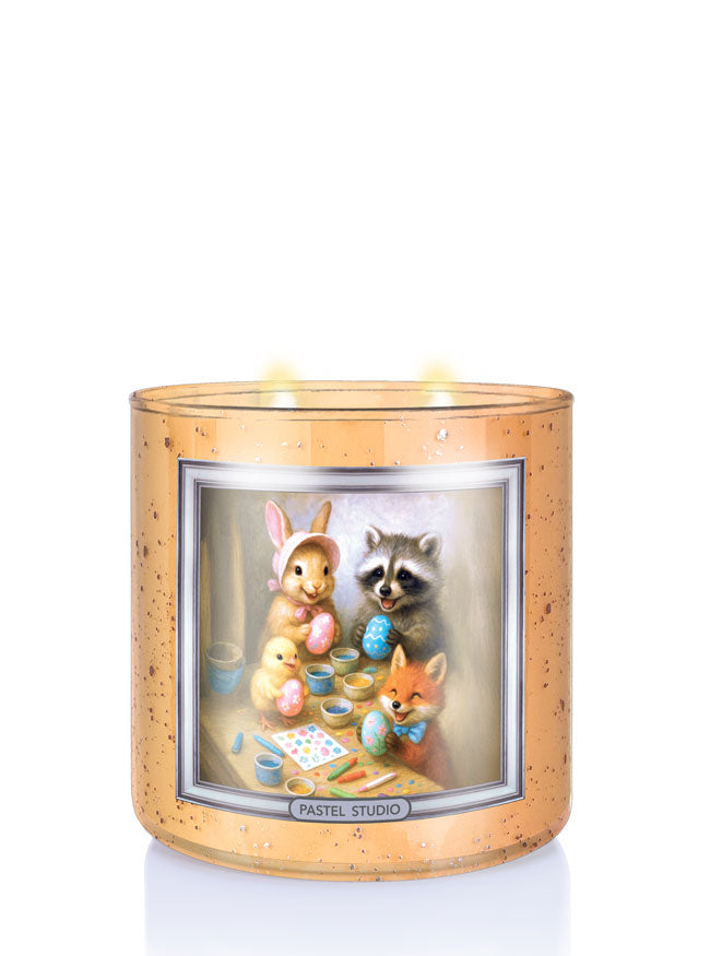 Decorative candle with Easter-themed illustration of animals around a table with art supplies.