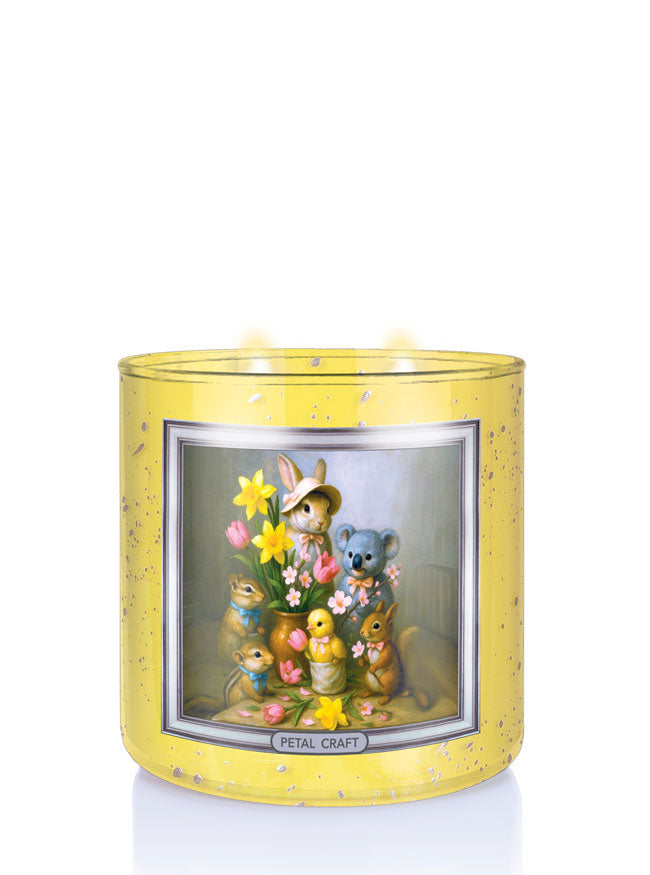 Decorative candle with cartoon animals and flowers in a yellow holder