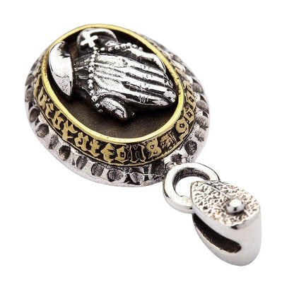 The side of the religious pendant showing the 'Good Vibrations' engraving on the brass bezel.