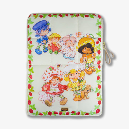 Top view of puffy laptop sleeve showcasing Strawberry Shortcake Berry Besties print, quilted panels, and wrist strap