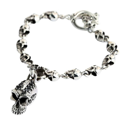 A heavy 42-gram punk bracelet made from a continuous link of solid sterling silver skulls with a central charm.