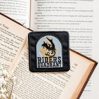 Riders Quadrant embroidered patch with dragon design on open book pages