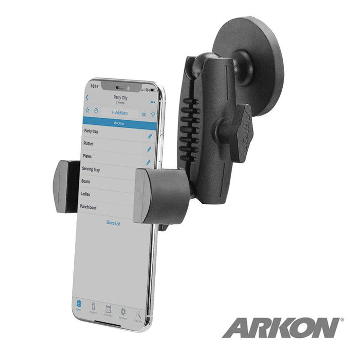 A smartphone displaying a shopping list app is held in a black RoadVise® Holder with Magnetic Mount attached to a surface. The ARKON logo appears in the lower right corner.