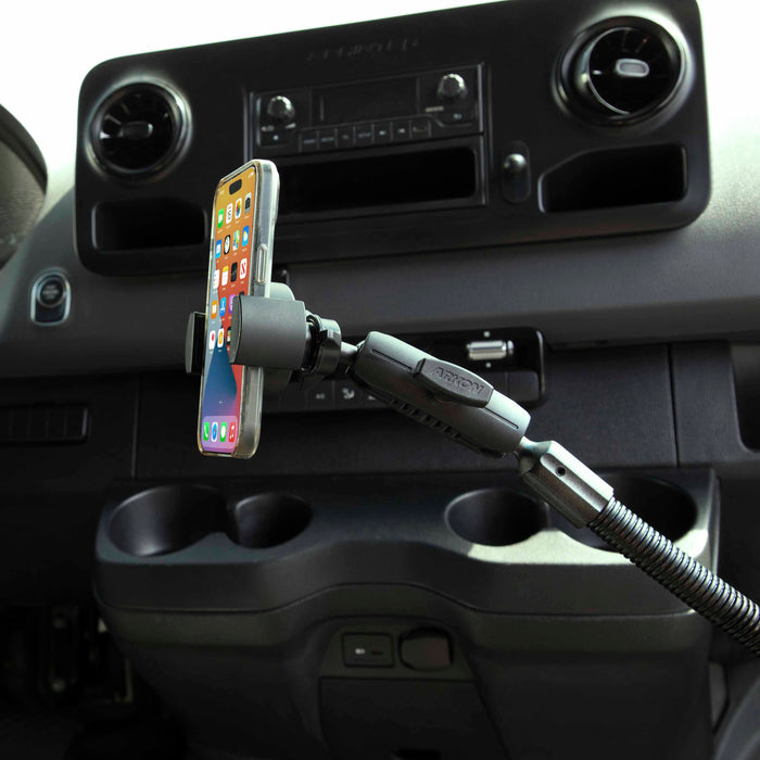 A smartphone is secured in the RoadVise® XL Heavy-Duty Seat Rail or Floor Tablet or Phone Mount, installed near the dashboard above the cup holders and controls, keeping apps visible for safe, easy access while driving.
