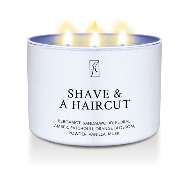 Candle in a white container labeled 'Shave & A Haircut' with flames on a white background