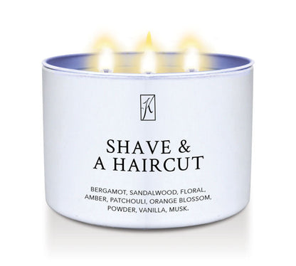 Candle in a white container labeled 'Shave & A Haircut' with flames on a white background