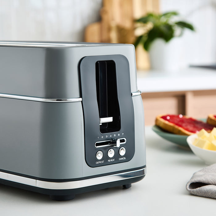 Grey toaster with slices of bread on a kitchen counter