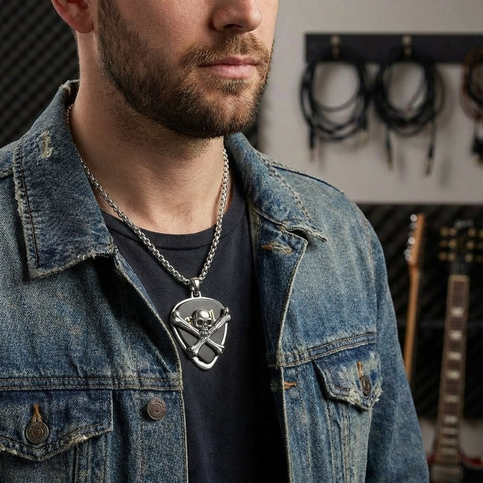 Man wearing skull guitar pick holder pendant with silver chain and denim jacket in music studio