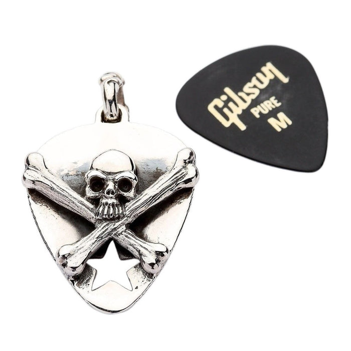Sterling silver skull pendant next to standard guitar pick for size comparison