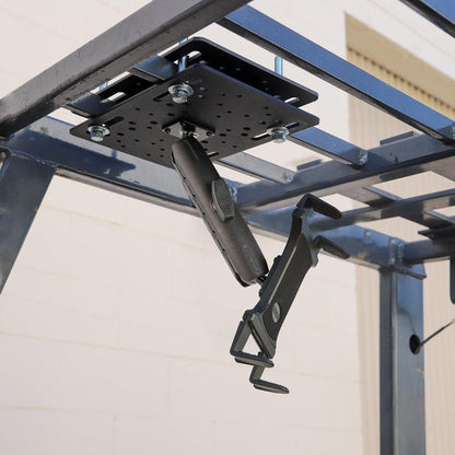 A Slim-Grip® Tablet Holder with Forklift Overhead Guard Mount and 6 Metal Shaft securely installed under a metal frame outdoors by a beige brick wall.
