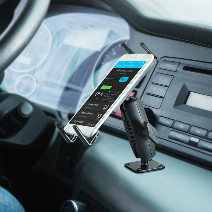 A Slim-Grip® Ultra Robust Tablet or Phone Mount with Metal AMPS Base securely holds a smartphone in a car, displaying navigation, with the phone, mount, steering wheel, and dashboard controls visible.