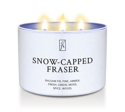 Candle in a white tin container labeled 'Snow-Capped Fraser' with flames on a white background